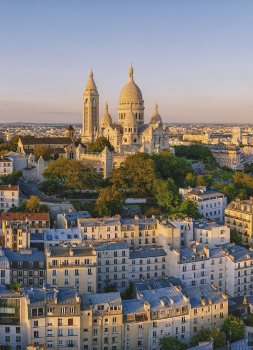 Photo de la Basilique sur la butte Montmartre et de la ville de Paris baignés par la lumière du soleil couchant