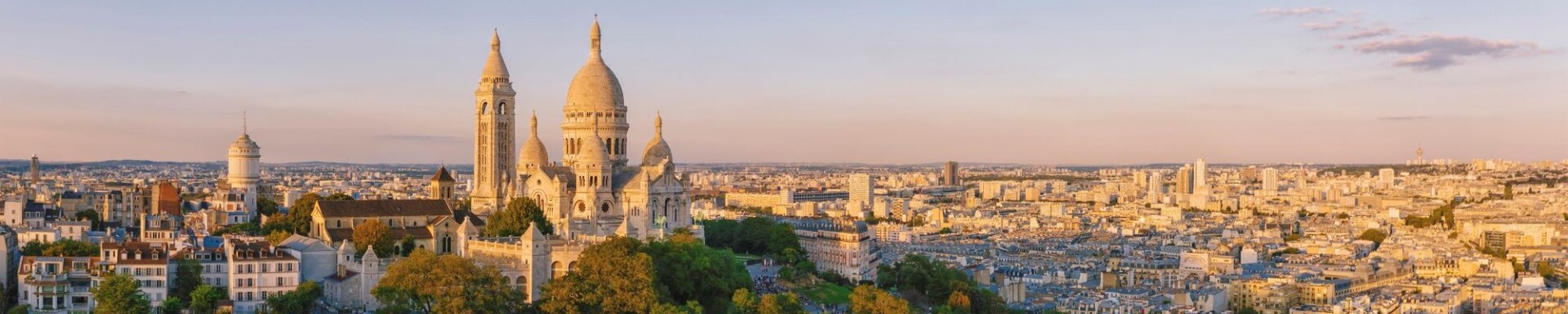Photo de la Basilique sur la butte Montmartre et de la ville de Paris baignés par la lumière du soleil couchant