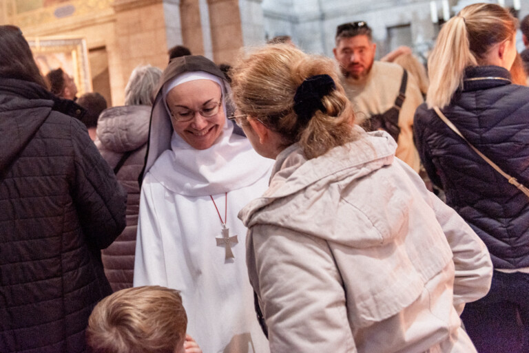 Soeur bénédictine parlant avec des gens dans la basilique